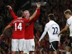 El jugador jalisciense (I) celebra el marcador con su compañero del Manchester, Wayne Rooney. AP  /