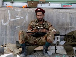 Enmedio del conflicto, un soldado yemení se da tiempo de leer el Corán hoy, en Adén. AP  /