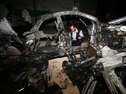 Un palestino observa un auto destruido tras un ataque aéreo israelí. EFE  /