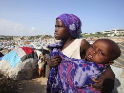 Una mujer carga a un bebé en el principal campo de desplazados de Berkulan, en las afueras de Mogadiscio. REUTERS  /