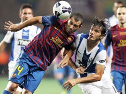 El argentino Javier Mascherano (I) cabecea el balón al lado del jugador del Oporto Kleber (D) durante el partido. AFP  /