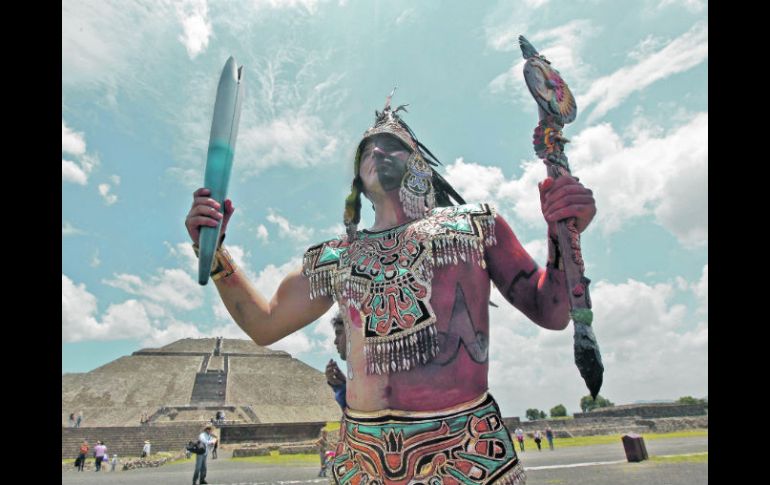 Un danzante ataviado como guerrero azteca porta la Antorcha Panamericana, tras encender el fuego en Teotihuacán. S. NÚÑEZ  /