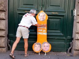 Un hombre pone un cartel con la leyenda Los derechos no se tocan en la puerta del ministerio de administración pública. EFE  /