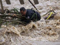 Miembros de Protección Civil retiran troncos del río Atoyac, para dejar fluir las fuertes corrientes que causaron las lluvias. NOTIMEX  /