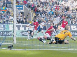 ''Chicharito'' (14) vence al arquero del Bolton,  Jussi Jaaskelainen, durante el partido de ayer en el Reebok Stadium. AP  /