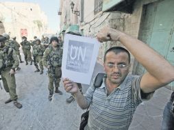 Un hombre palestino sostiene un cartel en el que se pide el reconocimiento de la ONU. EFE  /