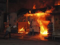 Un hombre trata de apagar el fuego que dejó la explosión de la granada de fragmentación, en la comunidad de Poptún. REUTERS  /