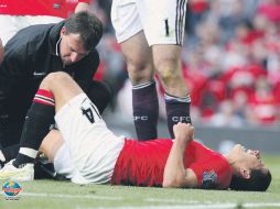 ''Chicharito'' grita de dolor, mientras es atendido por el cuerpo médico del Manchester United. EFE  /