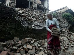 Una anciana recupera sus pertenencias entre los escombros de su vivienda en Bhaktapur, Nepal. EFE  /