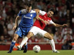 Mikel Arteta (D) del Arsenal se mueve con el balón ante Pablo Orbaiz (I), del Olympiakos. EFE  /