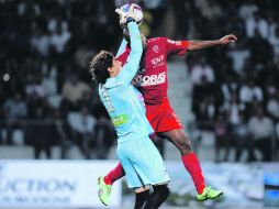 El arquero mexicano del Ajaccio, Memo Ochoa, le roba un balón al delantero del Dijon, Brice Jovial. AFP  /