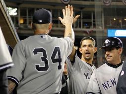 Jorge Posada felicita a A. J. Burnett durante el juego contra los Tigres de Detroit. AFP  /