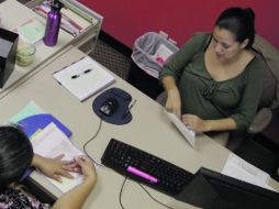 Jazmin Rivera (derecha), una trabajadora, social atiende a una inmigrante anónima que pide informes sobre la situación del Estado. AP  /