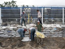En espera del huracán, trabajadores colocan sacos con arena alrededor del Estadio Panamericano de Voleibol de Playa en Vallarta. EFE  /