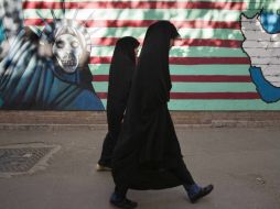 Mujeres iraníes caminan frente un muro anti EU en Teherán. REUTERS  /