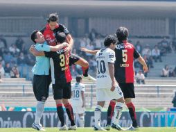 Jugadores del Atlas se abrazan festejando el triunfo sobre Pumas, ayer a mediodía en el Estadio Olímpico Universitario. MEXSPORT  /