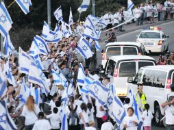 Cientos de israelíes se congratulan por la liberación de Gilad Shalit, mientras pasa la caravana que transporta al militar. AP  /