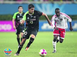 El atacante mexicano Othoniel Arce conduce el esférico ante la persecución del trinitario Micha Lewis. REUTERS  /