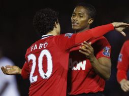 Antonio Valencia es felicitado por su compañero Fabio Da Silva por concretar el triunfo del ManU. REUTERS  /