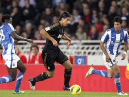 Sami Khedira (C), intenta alejarse del Mcdonald Mariga (I), y del delantero Carlos Vela (D), ambos de la Real Sociedad. EFE  /