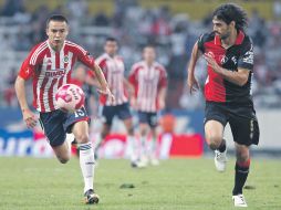 Érick ''Cubo'' Torres, autor del tanto de Chivas, conduce el balón, seguido de cerca por el rojinegro Jonathan Lacerda.  /