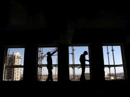 Dos hombres la construcción trabajan en un nuevo edificio de viviendas en el barrio de Jerusalén Este. EFE  /