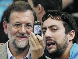 El centroderechista Mariano Rajoy se toma una foto con uno de los asistentes al mitin que el PP organiza en Madrid. EFE  /