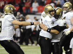 John Kasay (C)es felicitado por Drew Brees (I)y Chase Daniels (D) después de 'la patada de la salvación'. REUTERS  /