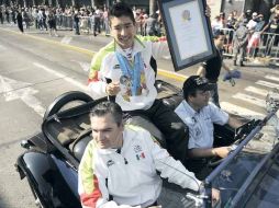 Julián Sánchez pasea por el desfile con reconocimiento en mano.  /