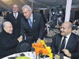 El secretario de Gobierno, Fernando Guzmán, saluda al cardenal durante la cena; los acompaña el alcalde de Tlajomulco, Enrique Alfaro.  /