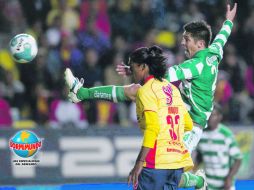 El delantero lagunero, Oribe Peralta, salta para disparar, ante la marca del defensa de Monarcas, Joel Huiqui. MEXSPORT  /