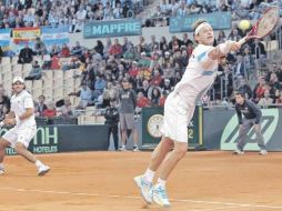 El tenista argentino David Nalbandián (der.) se estira para regresar la pelota ante la mirada de su compañero, Eduardo Schwank. EFE  /