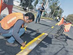 Estudiantes del ITESO pintaron la línea amarilla que divide la ciclovía de la zona de circulación para los automotores.  /
