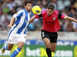 El delantero mexicano pelea un balón con el centrocampista francés del Jérémy Toulalan. EFE  /