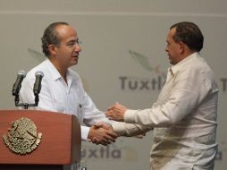 Felipe Calderón (i) saluda del mandatario de Honduras, Porfirio Lobo, en el cierre de la Cumbre de Tuxtla. REUTERS  /