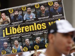 Un manifestante sostiene una pancarta que muestra fotografías de rehenes de las FARC. REUTERS  /