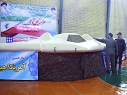 El general iraní Amir-Ali Hajizadeh (d) observando, el dron (avión no tripulado) US RQ-170 de la CIA interceptado. EFE  /