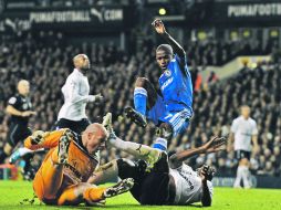 El defensa del Tottenham, Ledley King (der.), se barre y manda a “volar” al brasileño Ramires, del Chelsea. AFP  /