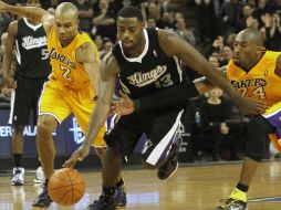 El guardia de los Kings de Sacramento, Tyreke Evans (c), persigue a la pelota entre Derek Fisher (i) y Kobe Bryant de los Lakers. AP  /
