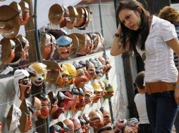 Transeúntes compran las tradicionales caretas para celebrar el fin de año en el país sudaméricano. EFE  /