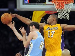 Andrew Bynum (der) evita una canaste de Fernández de los Nuggets. AP  /