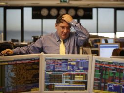 El corredor Luis Gouveia reacciona al hablar con un colega en una sala de operaciones de un banco portugués. AP  /