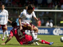 Pereyra recibe una falta durante el partido de este medio día en Toluca. AFP  /