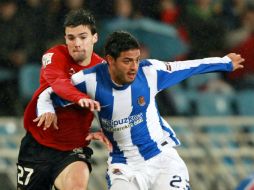 El centrocampista mexicano Carlos Vela (d) lucha por un balón con el defensa de Osasuna Eneko Satrústegui. EFE  /