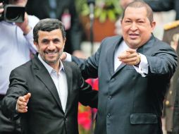 El presidente venezolano, Hugo Chávez (d), saluda a la prensa acompañado de su homólogo iraní, Mahmoud Ahmadinejad. EFE  /