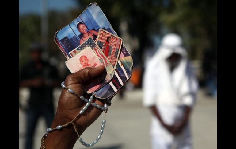 Ginnette Filemón sostiene en su mano fotos de sus tres hijas, un nieto y una tía, muertos durante el terremoto. EFE  /