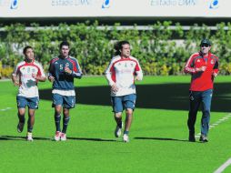 El técnico Fernando Quirarte (der.) trota en la cancha del Estadio Omnilife junto a Héctor Reynoso, Patricio Araujo y Marco Fabián.  /