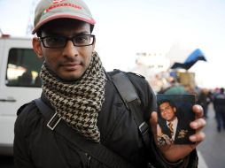 El hindú Kevin Rebello muestra una foto de su hermano Russel, mesero del cucero, que está desparecido. AFP  /