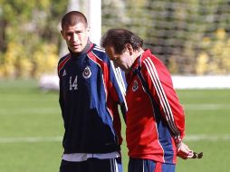 jorge Enríquez (izq) charla con Fernando Quirarte en el entrenamiento del Guadalajara.  /