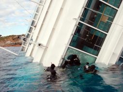 Los buzos nadan cerca de la nave de crucero Costa Concordia para seguir con las labores de rescate. AP  /